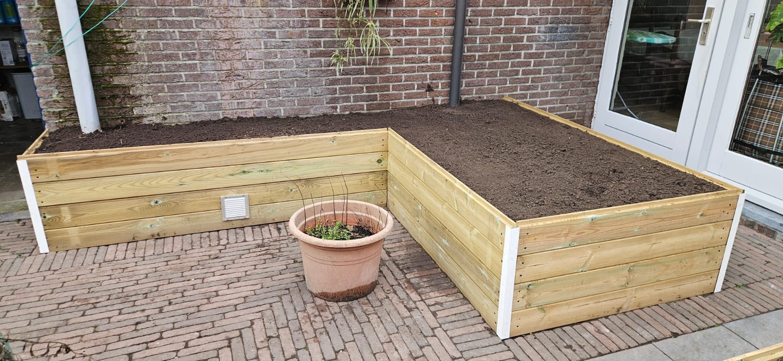 Houten plantenbak aangelegd door LV Tuinen